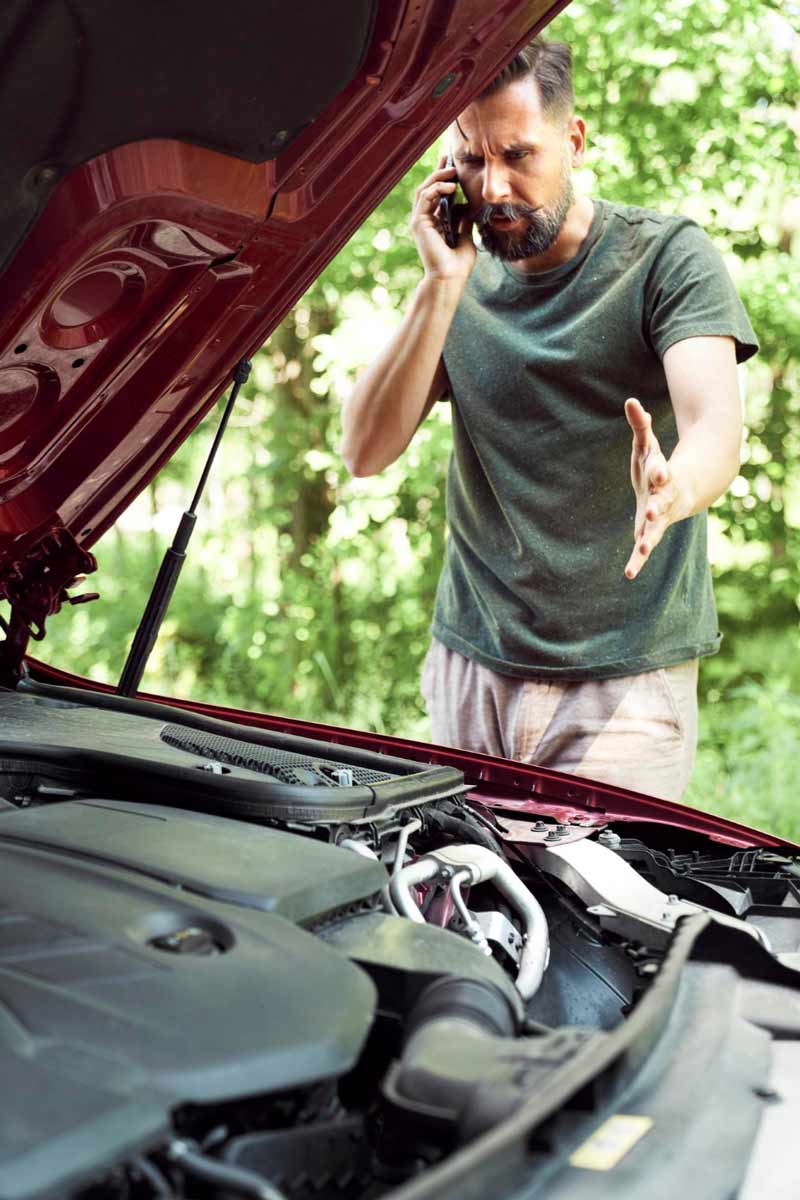 Junger Mann prüft Getriebeschaden bei Schrottauto Ankauf Schifferstadt